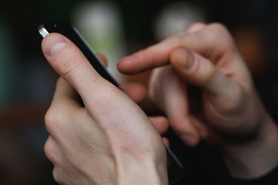 Cropped hand of person using mobile phone