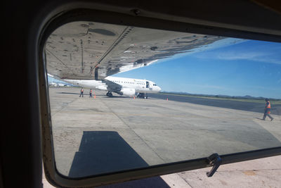 Airplane on airport runway against sky