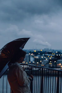 Side view of woman looking at cityscape