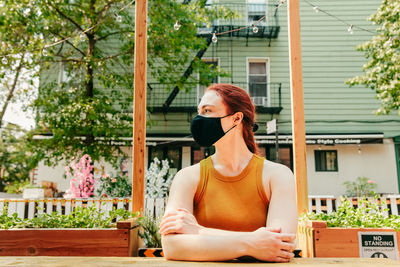 Woman looking away while sitting outdoors