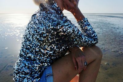 Rear view of woman standing at beach