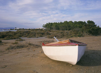 Boat moored on beach against sky