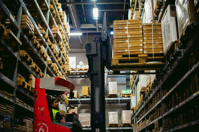 Worker driving forklift in factory