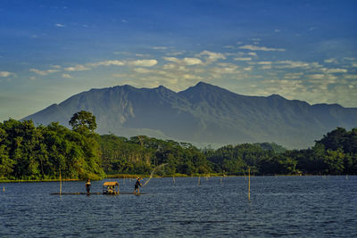 Scenic view of lake and mountains against sky