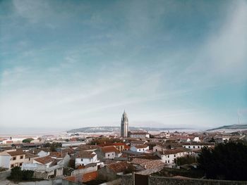 View of cityscape against cloudy sky