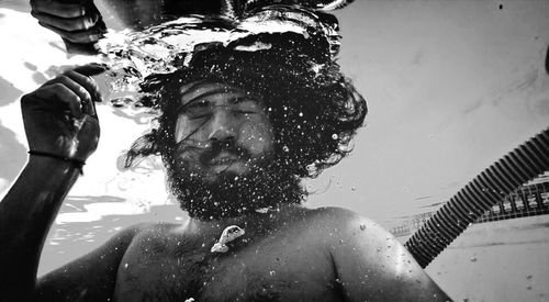 Close-up of man drinking water in swimming pool
