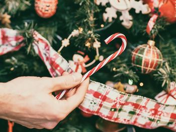 Cropped hand of person decorating christmas tree