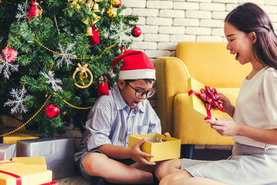 Friends sitting on christmas tree