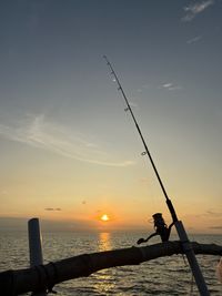 Long angle view  of fishing rod during sunset