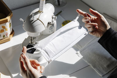 Crop seamstress checking handmade protective fabric mask just made