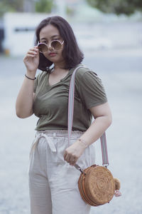 Portrait of teenage girl wearing sunglasses standing outdoors