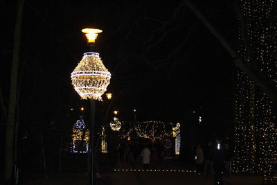Low angle view of illuminated lighting equipment at night