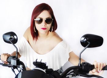 Young woman with sunglasses against white background