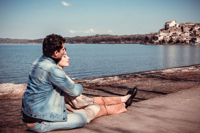 The young couple embraces while looking at anguillara sabazia, an ancient italian village.