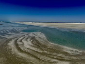 Scenic view of beach against blue sky