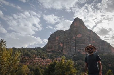 Full length of man standing on rock against sky