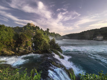 Scenic view of waterfall against sky