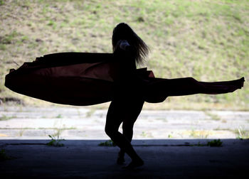 Full length of woman dancing against hill