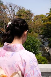 Rear view of woman against plants