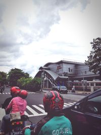 Rear view of people walking on road in city