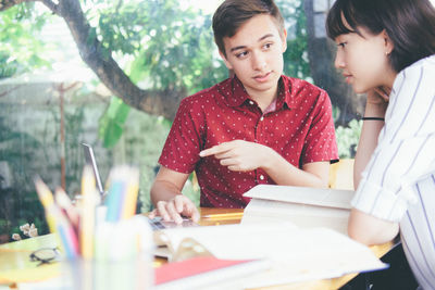 Young university students sitting at table