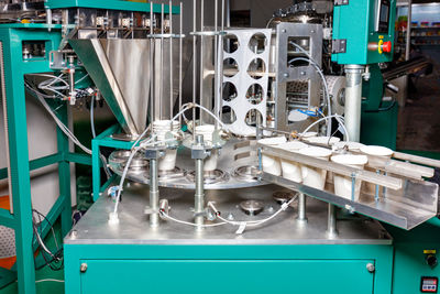 A fragment of an automatic production line for bottling and packaging food liquid yoghurts.
