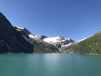 Scenic view of lake by mountains against clear blue sky berge wasser