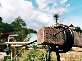 Close-up of rusty bicycle on field against sky