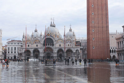 People in front of historic building during flood in city