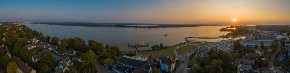 High angle view of buildings by sea against sky during sunset