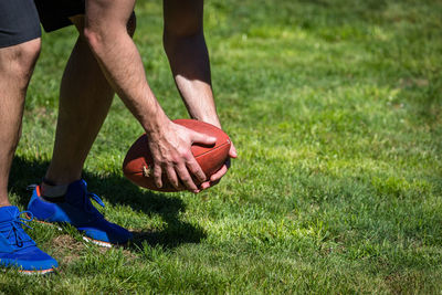 Low section of man playing soccer on field