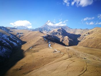 Scenic view of mountains against blue sky