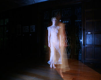 Blurred motion of woman walking in house