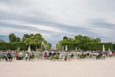 People amidst fountain against sky