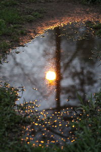 Reflection of illuminated puddle in lake