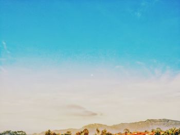 Scenic view of mountains against blue sky