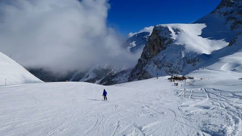 Person skiing on snowcapped mountain against sky