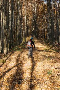 Tourist man hiking in autumn forest