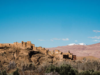 Panoramic view of people on landscape against blue sky