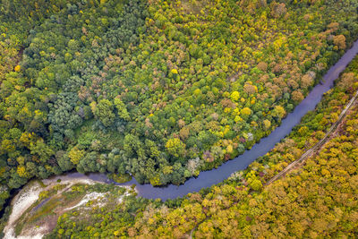 Aerial view from drone of the river across mountain hills with autumn trees