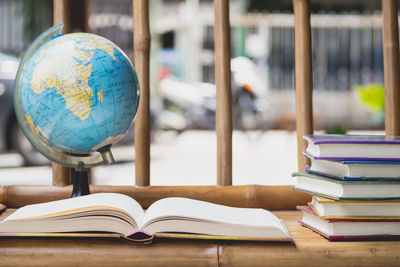 Close-up of books and globe on table