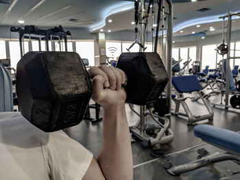 Cropped hand of man exercising in gym