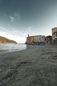 Surface level of beach against sky in city