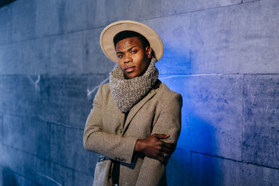 Portrait of man standing against wall