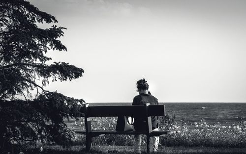 Man relaxing on water against clear sky