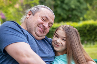 Father and daughter communicate, indulge, make faces in the park. 