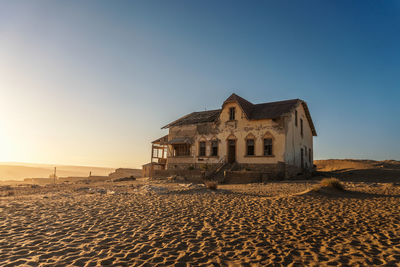 House on beach against clear sky