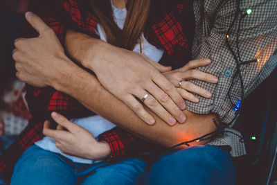 Midsection of couple holding hands