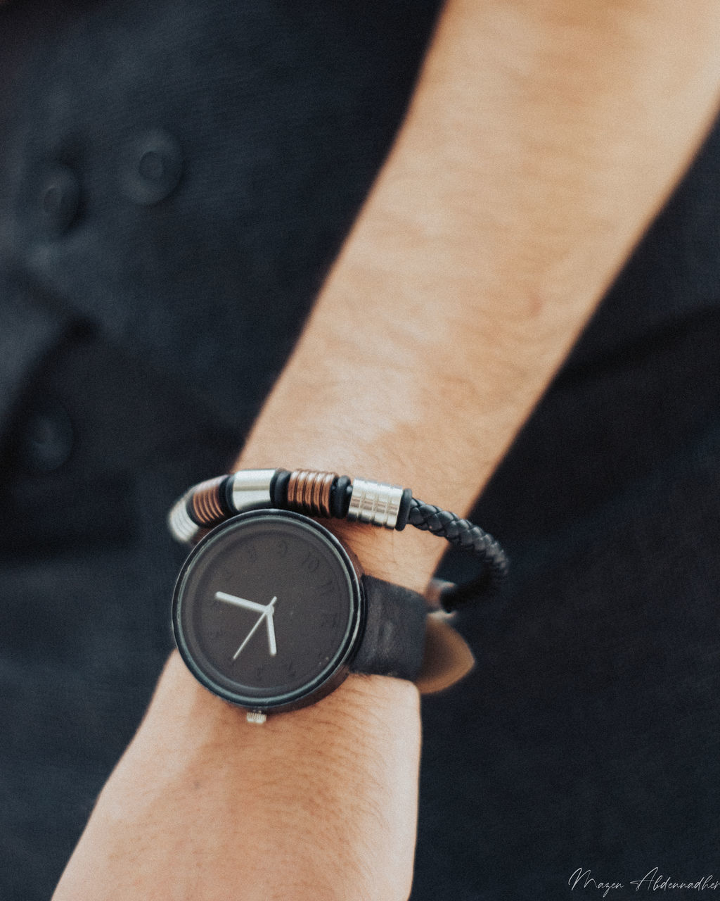 HIGH ANGLE VIEW OF HAND HOLDING CLOCK AGAINST BLURRED BACKGROUND