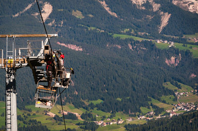 Overhead cable car over mountains against sky